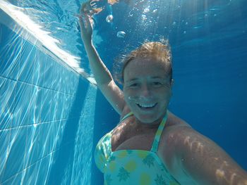 Portrait of smiling woman swimming in pool