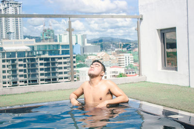 Portrait of shirtless man in swimming pool