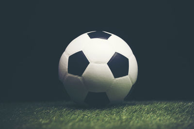 Close-up of soccer ball against black background