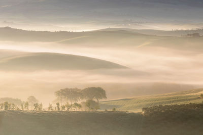 Scenic view of landscape against sky during foggy weather