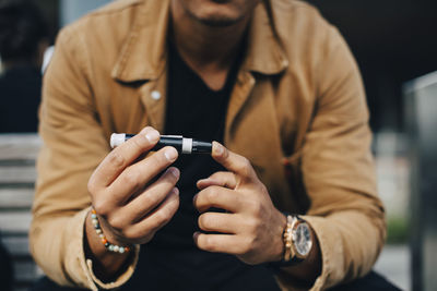 Midsection of man using mobile phone