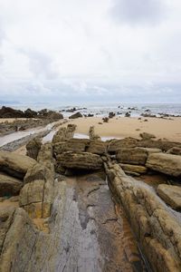 Scenic view of rocks on beach against sky