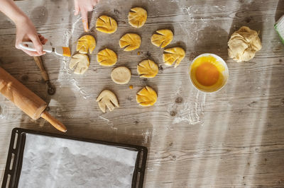 Cropped image of hand making cookies on table