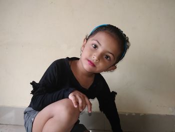 Portrait of cute girl against wall