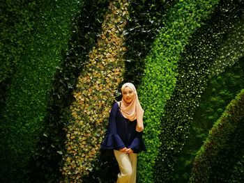 Portrait of woman in hijab standing by plants at park