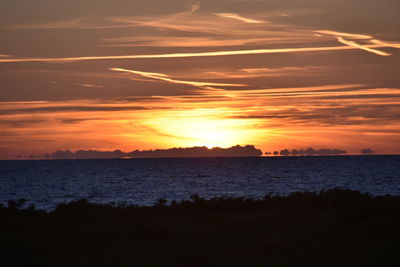 Scenic view of sea against romantic sky at sunset