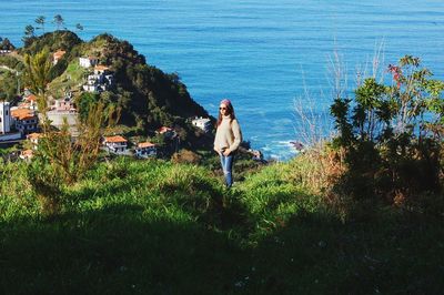 High angle view of woman standing in sea against sky