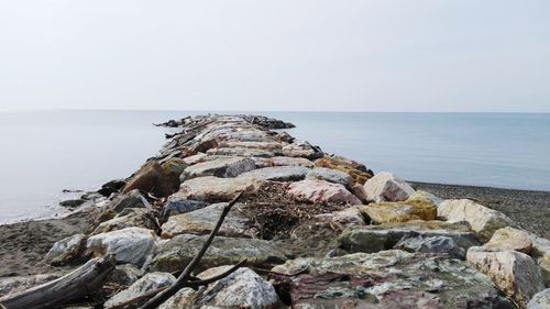 Rock formation on beach against sky