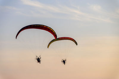 Low angle view of person paragliding against sky