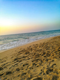 Scenic view of beach against clear sky during sunset