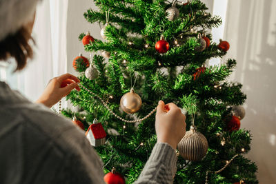 The girl decorates the christmas tree for the holiday. preparing for christmas and new year. 