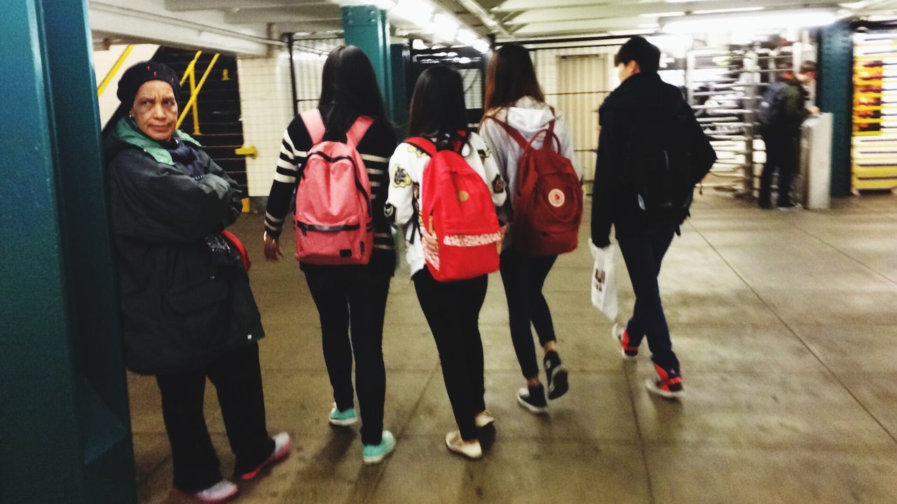 lifestyles, indoors, casual clothing, leisure activity, standing, togetherness, person, men, young adult, full length, railroad station, front view, transportation, travel, public transportation, young women, passenger