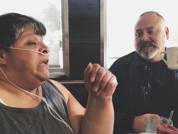 Portrait of man sitting on window
