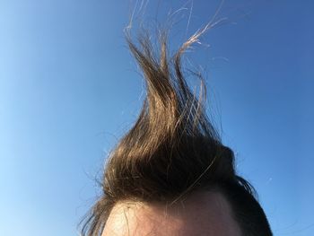 Close-up of woman against blue sky