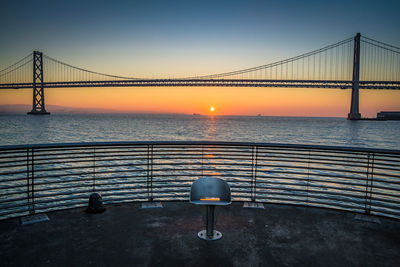 Bay bridge against clear sky at sunrise