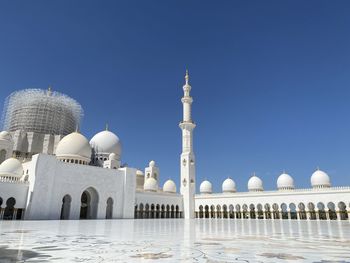 Low angle view of mosque against clear blue sky