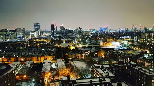 High angle view of illuminated cityscape against sky at night