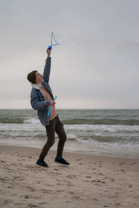 Full length of man standing on beach against sky