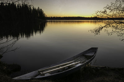 Boat moored at lakeshore against clear sky