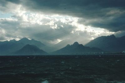 Scenic view of sea and mountains against sky