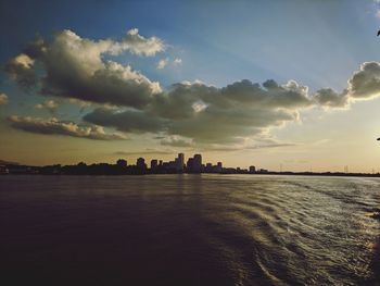 Scenic view of sea and buildings against sky during sunset