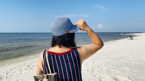 Rear view of woman standing at beach