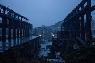 Illuminated buildings in city against clear sky at dusk