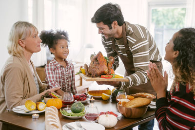 People sitting by food on table