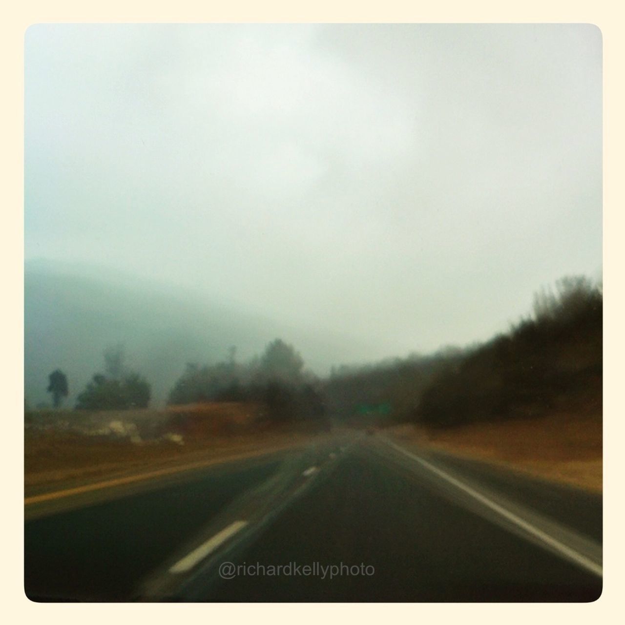 transportation, road, the way forward, road marking, diminishing perspective, country road, vanishing point, transfer print, sky, auto post production filter, windshield, tree, car, landscape, mode of transport, vehicle interior, highway, fog, on the move, car point of view