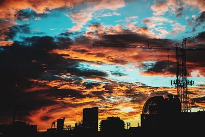 Low angle view of silhouette buildings against cloudy sky