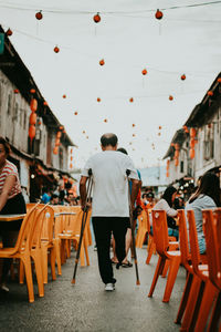 Rear view of people walking on chairs