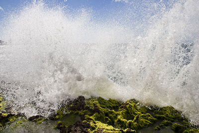 Wave breaks strongly on the stones of the seashore and the water jumps and scatters with force