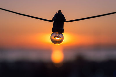 Light bulb against sky at sunset