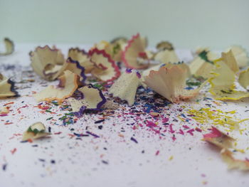 Close-up of colored pencil shavings on table