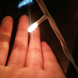 Close-up of hand holding illuminated lamp