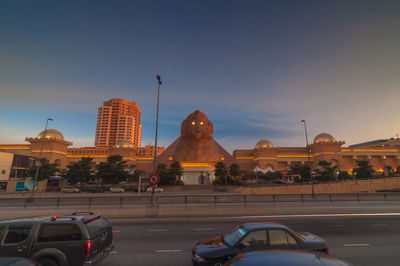 Statue in city at sunset