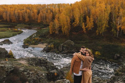 Happy people in love are travel hike in nature in the autumn forest. romantic trip to countryside