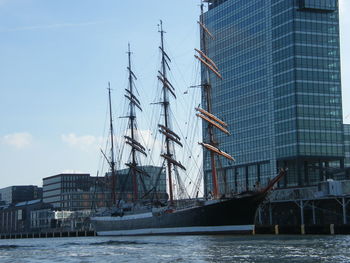 Sailboats in sea against buildings in city