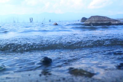 Surface level of rocks in sea against sky