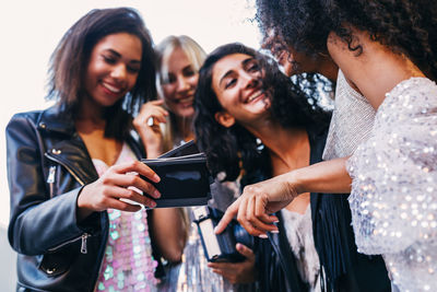 Cheerful friends holding photographs