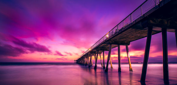 Pier over sea against sky during sunset