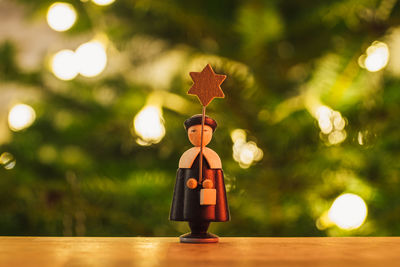 Illuminated toy by tree against blurred background