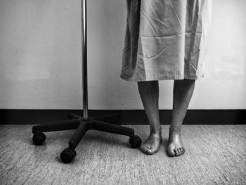 Low section of woman standing on carpet at home