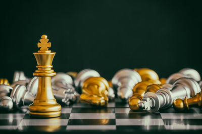 Close-up of chess pieces on board against black background