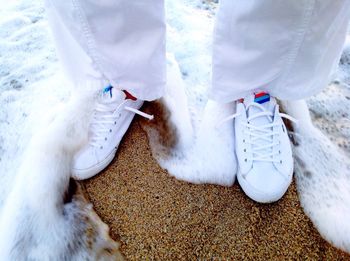 Close-up low section of man standing on surf