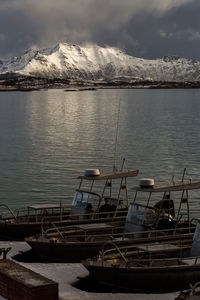 Sailboats moored in lake against sky