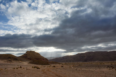 Scenic view of mountains against cloudy sky