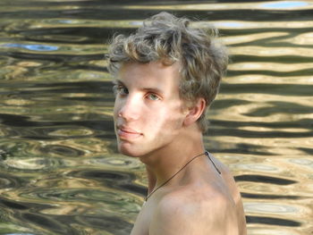 Portrait of shirtless young man in swimming pool