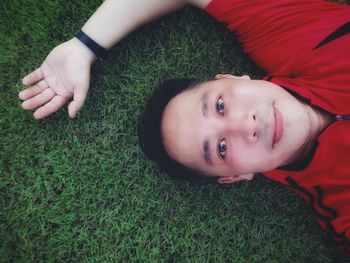 Portrait of boy lying on grassy field