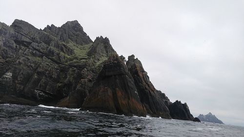 Rock formations by mountains against sky